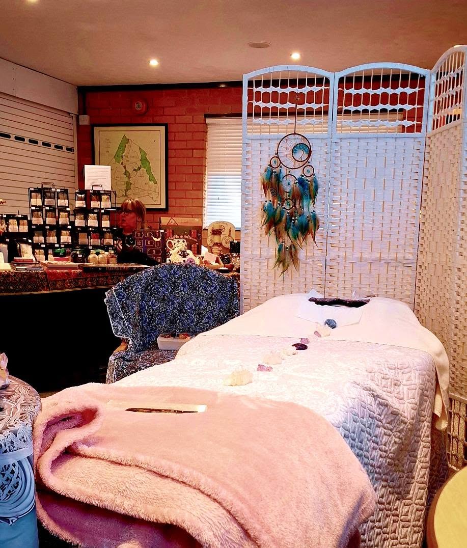 A crystal healing therapy treatment room with a bed ready for a session